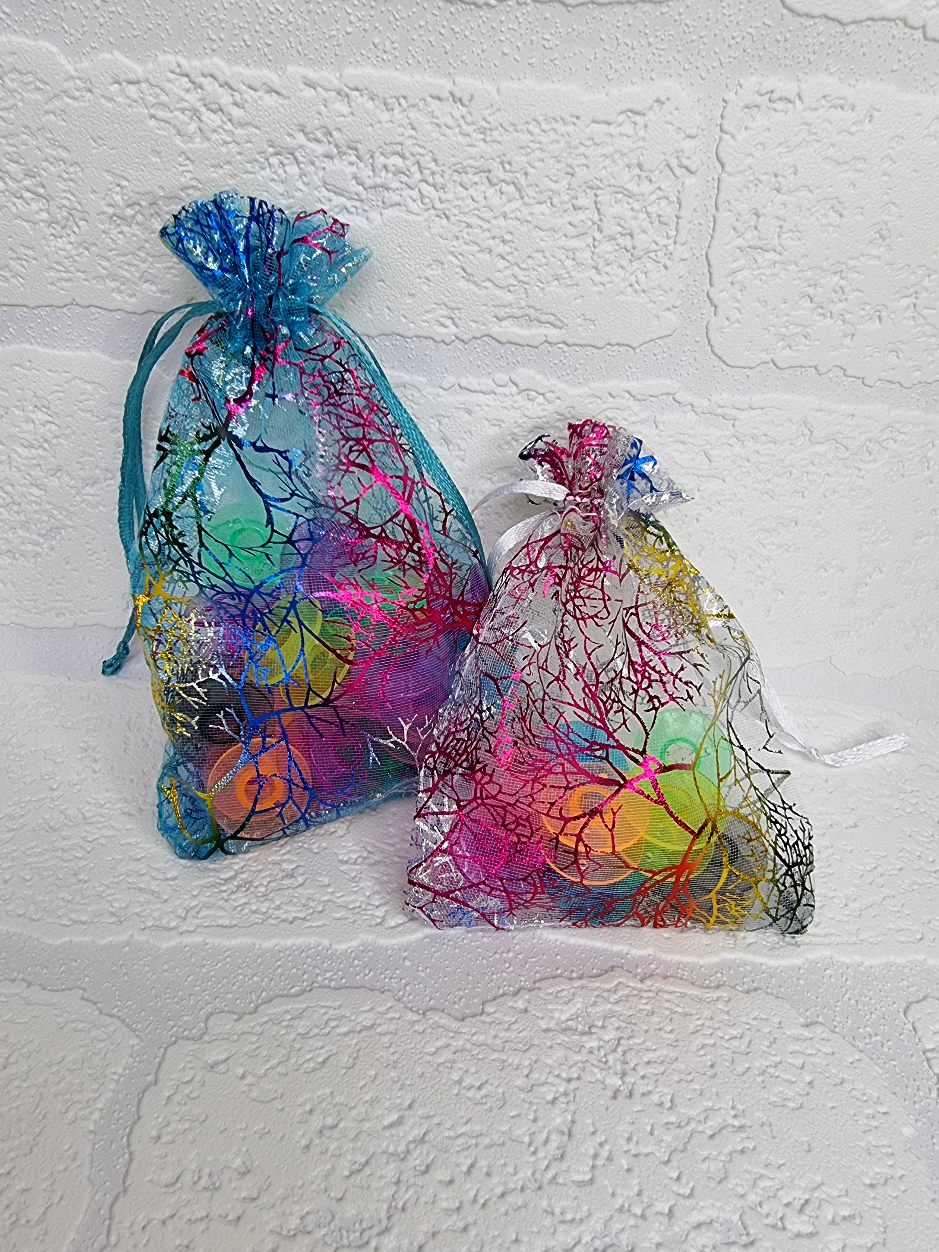 Beautiful organza gift bags containing our rainbow clear plastic bobbins