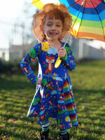 Load image into Gallery viewer, Beautiful dress made to show off our adorable fox design, modeled by a beautiful little one clutching matching umbrella. Picture shows Adorable foxes in cute habitats, one with unbrella under rain cloud, one sleeping on tree stump, one soaking up the rain and one standing under the sun. Exclusive design for pre-order at Colourburst Fabrics 
